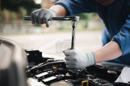 Foto de Service outdoor. Close up hands of auto mechanic man working on car engine using wrench to repair and maintenance, broken car care check and fixed the problem and services insurance - Imagen libre de derechos