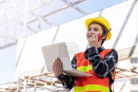 Photo for Asian engineer architect worker woman working at build construction site use laptop and talking with radio, engineering hold computer and radio discuss operate and control worker employee to building - Royalty Free Image