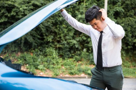 Téléchargez les photos : Asiatique homme d'affaires voiture panne cassée, en colère jeune homme stressé se pose problème panne de voiture problème à la recherche dans la frustration à panne moteur le matin, accident sur la route en plein air, en retard pour le travail d'affaires - en image libre de droit