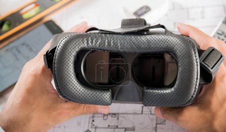 Téléchargez les photos : Conception de bâtiments architecturaux retenir lunettes 3D VR et plans de construction avec des plans de projet en papier, conception homme modifier bâtiment ou architecture, industrie de la technologie, Architecte lieu de travail - en image libre de droit