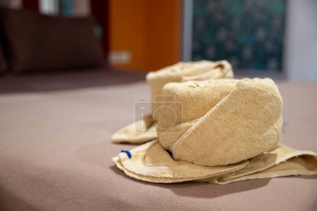 Photo for Yellow towel on bed decoration in bedroom interior, Freshly laundered fluffy towels, Towel in hotel room, Beautifully folded toiletries - Royalty Free Image