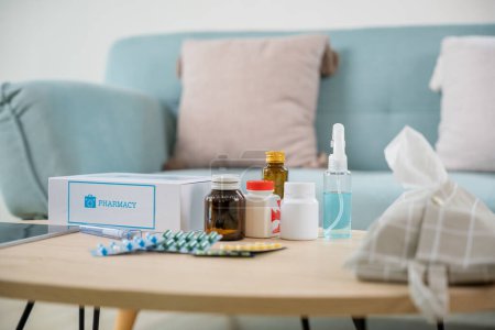 Téléchargez les photos : Home medicine with medicine package box free first aid kit with pills from pharmacy hospital delivery service at home on table in living room, online purchase delivery of medicines to your home - en image libre de droit