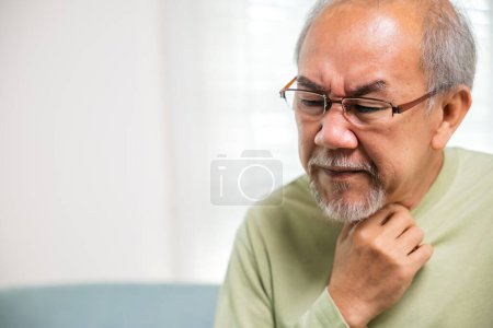 Asian old man painful in the sore throat, retirement senior man feeling pain use hands holding neck, Elderly people have dysphagia due to eating, Health care and medicine concept