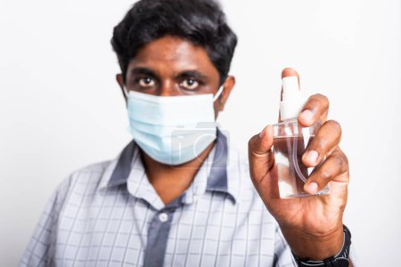 Photo for Closeup Asian black man wearing protective face mask fear in eye holding show sanitizer spray, hygiene prevention COVID-19 virus or coronavirus protection concept isolated on white background - Royalty Free Image
