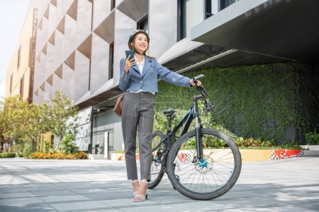 Téléchargez les photos : Asian beautiful young woman use smart mobile phone talk with business during go to office work at city street with bicycle, Happy lifestyle business female commuting outside in morning, Eco friendly - en image libre de droit