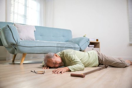 Photo for Elder man falling on the floor alone with walking stick on living room at home, Older senior man headache lying on the floor after falling down, Health care and medicine concept - Royalty Free Image