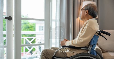 Téléchargez les photos : Solitaire âgé réfléchi triste vieil homme regarder à l'extérieur des fenêtres dans la chambre à coucher à la maison de retraite, asiatique homme âgé handicapé se sentent déprimé seul assis dans un fauteuil roulant regardant par la fenêtre à l'hôpital - en image libre de droit