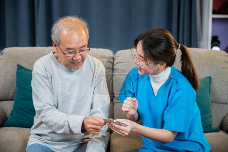 Photo for Asian nurse with physician explaining prescription medicine to attentive senior man at home, Doctor woman explain dosage pill old man, Healthcare worker caregiver visiting in house in living room - Royalty Free Image