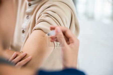 Photo for Asian elderly old man getting coronavirus vaccine with nurse, Doctor giving injection with syringe to senior man at clinic or hospital, medical and healthcare - Royalty Free Image