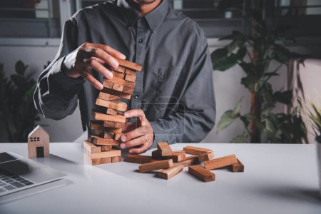 Photo for Business fail danger building tower challenge game building. Businessman hand pulling out wood block and failed the tower is falling down he wrong strategy decision - Royalty Free Image