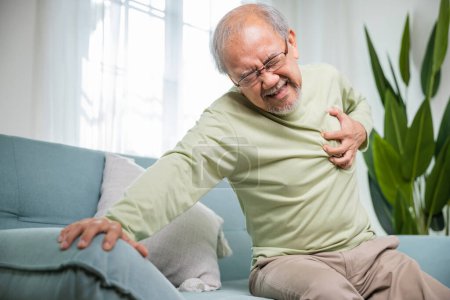 Photo for Senior man bad pain hand touching chest having heart attack, Asian older man have congenital disease suffering from heartache alone at home his heart aches, Old age retirement health problems diseases - Royalty Free Image