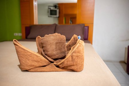 Photo for Yellow towel on bed decoration in bedroom interior, Freshly laundered fluffy towels, Towel in hotel room, Beautifully folded toiletries - Royalty Free Image