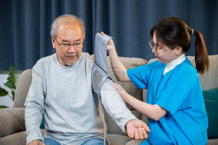 Photo for Asian nurse visit patient senior man at home she measuring arterial blood pressure on arm in living room, Doctor woman examine do checking old man client heart rate with pulsimeter monitor, Healthcare - Royalty Free Image