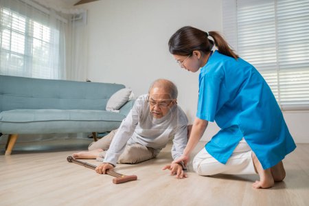 Photo for Asian older senior man falling down on lying floor and woman nurse came to help support, Disabled elderly old man patient fall down and caring young assistant at nursing home - Royalty Free Image