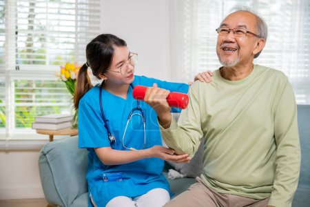 Photo for Asian nurse physiotherapist helping senior man in lifting dumbell at retirement home, Young nurse take care support training elderly sitting on sofa using dumbbell workout exercise, Healthcare medical - Royalty Free Image