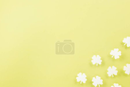 Téléchargez les photos : Happy St. Patricks Day decoration background. Flat lay of cutting paper clover leaves festive decor, shamrocks leaves holiday symbol with copy space on colour background, Banner greeting card concept - en image libre de droit