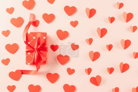 Foto de Top view flat lay of paper hearts and gift box on pastel pink background surprise your loved with space for text, birthday greeting, web design banner holiday, Happy Valentine Day Background - Imagen libre de derechos