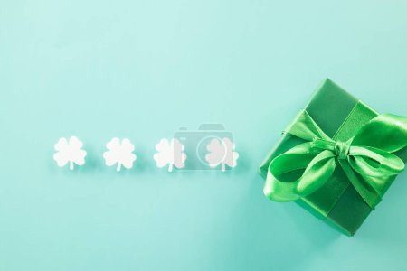 Foto de Happy St Patricks Day decoration background. above view gift box green clover leaves festive decor, shamrocks leaves holiday symbol with copy space on pastel background, Banner greeting card concept - Imagen libre de derechos