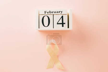 Téléchargez les photos : Pink awareness ribbon sign and Calender 4 February of World Cancer Day campaign on pastel pink background with copy space, concept of medical and health care support - en image libre de droit