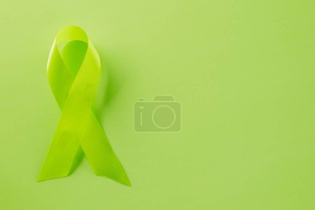 Téléchargez les photos : Green awareness ribbon of Gallbladder and Bile Duct Cancer month isolated on green background with copy space, concept of medical and health care support - en image libre de droit
