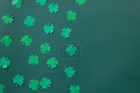 Foto de Happy St. Patricks Day decoration background. Flat lay of cutting paper clover leaves festive decor, shamrocks leaves holiday symbol with copy space on colour background, Banner greeting card concept - Imagen libre de derechos
