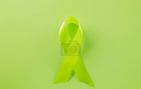 Téléchargez les photos : Green awareness ribbon symbol of Gallbladder and Bile Duct Cancer month isolated on green background with copy space, concept of medical and health care support, Cancer awareness, World bipolar day - en image libre de droit