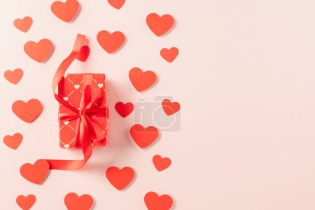 Téléchargez les photos : Top view flat lay of paper hearts and gift box on pastel pink background surprise your loved with space for text, birthday greeting, web design banner holiday, Happy Valentine Day Background - en image libre de droit
