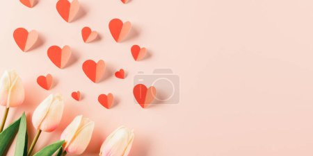 Foto de Happy Valentines Day background. Top view flat lay of red paper hearts shape and pink tulips flower on pink background with copy space - Imagen libre de derechos