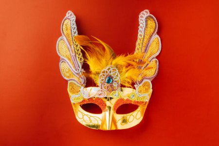 Foto de Happy Purim carnival. Carnival mask for Mardi Gras celebration isolated on red background with copy space, jewish holiday, Purim in Hebrew holiday carnival ball, Venetian mask, masquerade accessory - Imagen libre de derechos