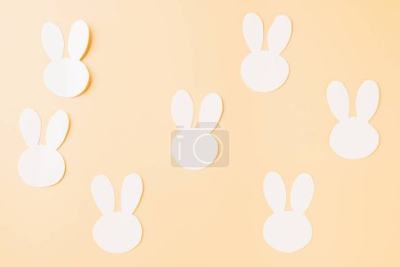 Téléchargez les photos : Easter Day Concept. Top view handmade white paper rabbit cutting isolated on pastel background with copy space for your text, Happy Easter Bunny holiday - en image libre de droit