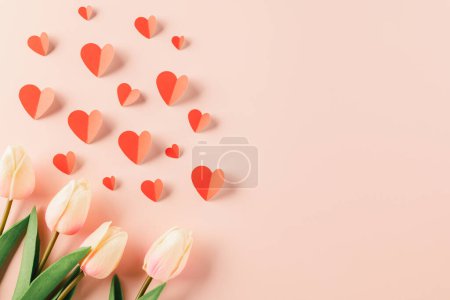 Téléchargez les photos : Happy Valentines Day background. Top view flat lay of red paper hearts shape and pink tulips flower on pink background with copy space, Valentine day concept, Banner of holiday - en image libre de droit