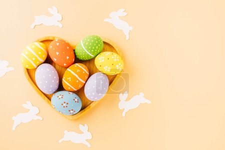 Photo for Overhead easter eggs with rabbit paper cut in shape heart isolated on pastel background, Funny decoration paper round blank, Happy Easter Day greeting card, composition banner web design holiday - Royalty Free Image