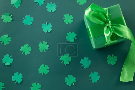 Foto de Happy St Patricks Day decoration background concept. shamrocks leaves holiday symbol with copy space on green background, above view gift box green clover leaves - Imagen libre de derechos