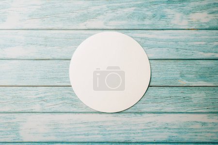 Foto de Top view blank round white paper isolated on blue wooden background, abstract geometric shapes, with copy space design element background, paper circle - Imagen libre de derechos