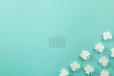 Photo for Happy St. Patricks Day decoration background. Flat lay of cutting paper clover leaves festive decor, shamrocks leaves holiday symbol with copy space on colour background, Banner greeting card concept - Royalty Free Image