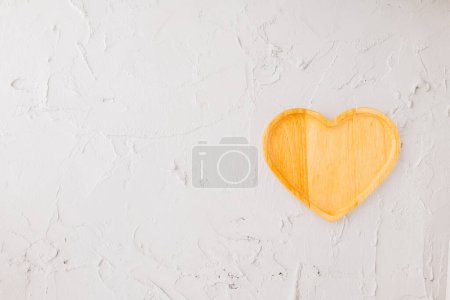 Téléchargez les photos : Plateau en bois vide en forme de coeur isolé sur fond de ciment blanc, vue de dessus, pose plate, assiette ou bol en bois pour la nourriture, Collection, joyeuse Saint-Valentin - en image libre de droit