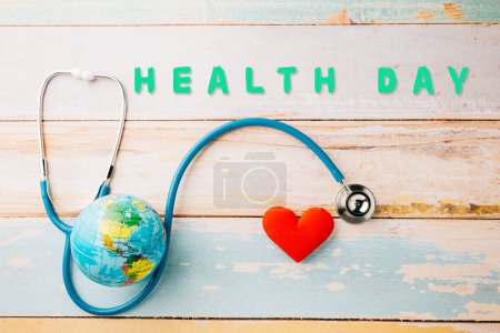 Foto de World Health Day. Yellow doctor stethoscope and world globe with Red heart shape on wooden background with copy space, Save world day, Green Earth Environment, Healthcare and medical concept - Imagen libre de derechos