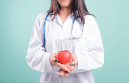 Photo for Doctor Day, beautiful nurse young woman smiling with doctor stethoscope holding red head on hand isolated on blue background with copy space, Medical healthcare staff service concept - Royalty Free Image