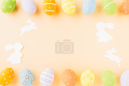 Téléchargez les photos : Easter eggs bunny and rabbit white paper cutting isolated on pastel background. Funny decoration, Happy Easter Day, Festive composition banner design holiday background - en image libre de droit