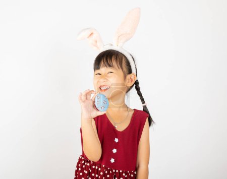 Photo for Happy Easter Day. Smile Asian little girl wearing easter bunny ears holding colorfull eggs on hands isolated on white background with copy space, Happy child in holiday - Royalty Free Image