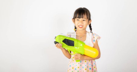 Photo for Happy Songkran Day, Asian little girl holding plastic water gun, Thai child funny hold toy water pistol and smile, isolated on white background, Thailand Songkran festival national culture concept - Royalty Free Image