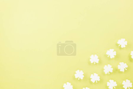 Téléchargez les photos : Happy St. Patricks Day decoration background. Flat lay of cutting paper clover leaves festive decor, shamrocks leaves holiday symbol with copy space on colour background, Banner greeting card concept - en image libre de droit