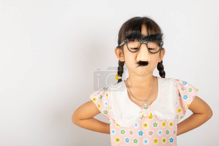 Photo for April Fools Day. Portrait of Funny kid little girl clown wears a big nos and glasses and has a mustache isolated on white background with copy space, Happy smile child festive decor - Royalty Free Image