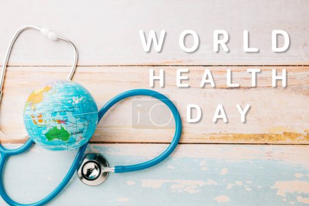 Photo for World Health Day. Blue doctor stethoscope and world globe isolated on wooden background with copy space for text, Save world day, Green Earth Environment, Healthcare and medical concept - Royalty Free Image