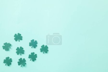 Foto de Happy St. Patricks Day decoration background. Flat lay of cutting paper clover leaves festive decor, shamrocks leaves holiday symbol with copy space on colour background, Banner greeting card concept - Imagen libre de derechos
