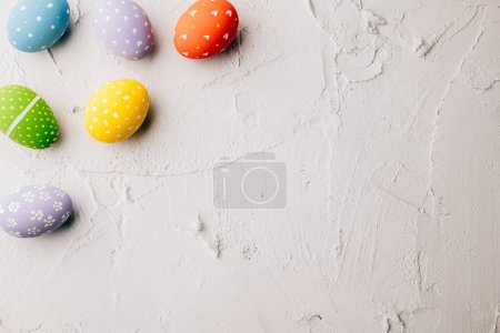 Téléchargez les photos : Easter Day Concept. Top view holiday banner background web design white colorful easter eggs painted on white cement background with empty copy space, celebration greeting card, overhead, template - en image libre de droit