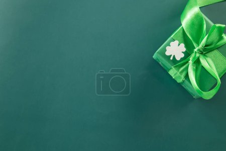 Foto de Happy St Patricks Day decoration background. above view gift box green clover leaves festive decor, shamrocks leaves holiday symbol with copy space on green background, Banner greeting card concept - Imagen libre de derechos