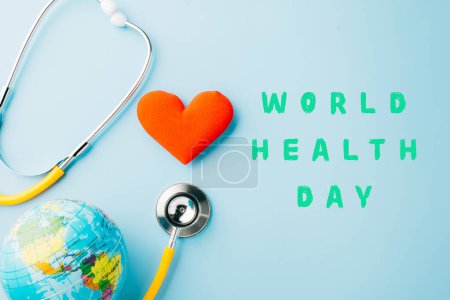 Photo for World Health Day. Yellow doctor stethoscope and world globe with Red heart shape isolated on blue background with copy space, Save world day, Healthcare life Insurance, Health care and medical concept - Royalty Free Image