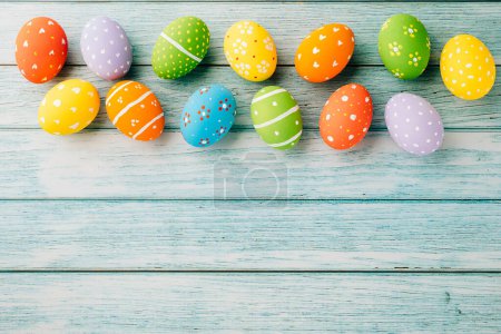 Téléchargez les photos : Easter Day Concept. Top view holiday banner background web design white colorful easter eggs painted on blue wood background with empty copy space, celebration greeting card, overhead, template - en image libre de droit