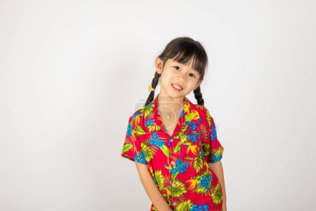 Téléchargez les photos : Happy Songkran Day, Asiatique enfant fille avec chemise florale tenir pistolet à eau, Thai enfant drôle tenir jouet pistolet à eau et sourire, isolé sur fond blanc, Thaïlande Songkran festival concept de culture nationale - en image libre de droit